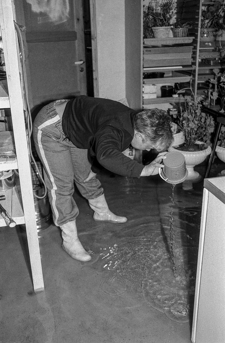 Flom i Follo. Dame øser vann i kjelleren med plastbøtte. Flom over veier og jorder mellom Horgenkrysset i Ås og Frogn. Biler kjører i flomvannet.