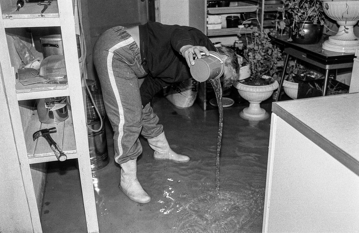 Flom i Follo. Dame øser vann i kjelleren med plastbøtte. Flom over veier og jorder mellom Horgenkrysset i Ås og Frogn. Biler kjører i flomvannet.