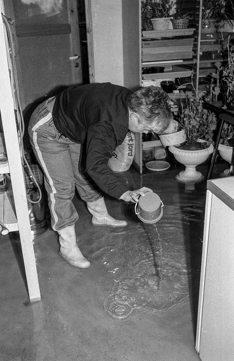 Flom i Follo. Dame øser vann i kjelleren med plastbøtte. Flom over veier og jorder mellom Horgenkrysset i Ås og Frogn. Biler kjører i flomvannet.