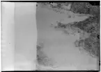 Flygfotografi av landskap kring Märkäjärvi i norra Finland under finska vinterkriget, 1940. Spaningsbild över skog, väg och fält / sjö tagen av flygare vid F 19, Svenska frivilligkåren i Finland.