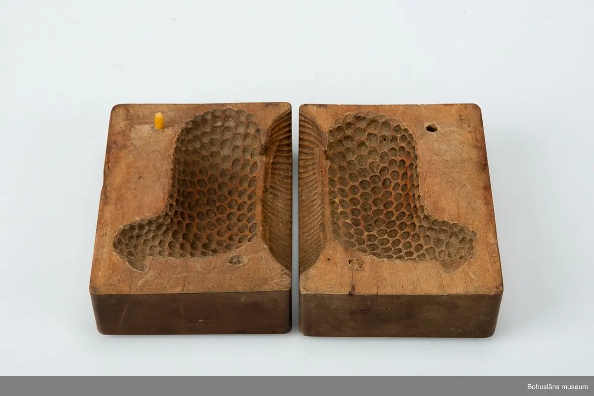 Tvådelad smörform som formar smöret till ett liggande lamm.

Ur handskrivna katalogen 1957-1958:
Smörformare
I 2 delar, a-b, mått (hopsatt)13,5 x 10,3 x 7,8 cm, av trä, omålat; form till höna el. dyl. Hel.