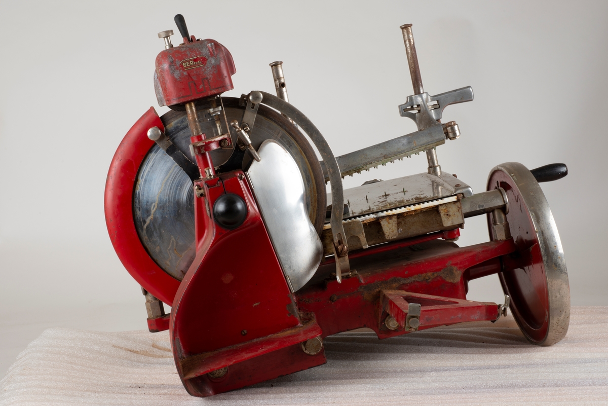 Skjæremaskin for kjøttmat i metall. Rød, blank, hvit. jern, stål og marmor
Produsert av Berkel i Rotterdam, Holland (Nederland)