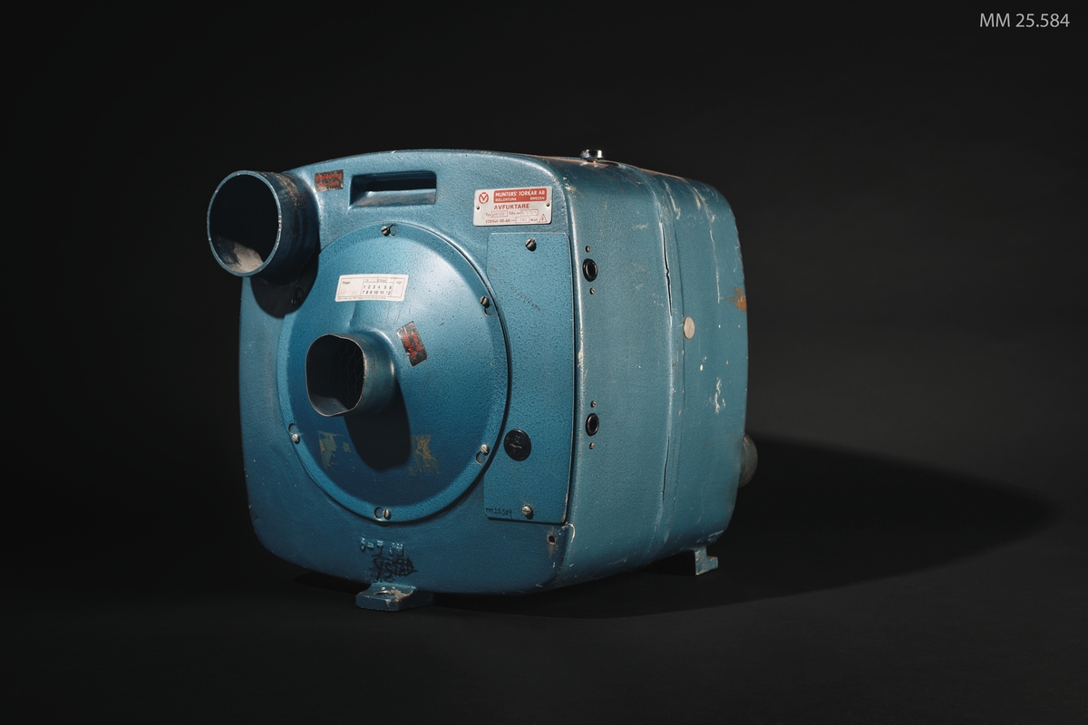 Blå fyrkantig box men fyra rör, två pa vadera sida. Tempertaturmätere på ovansidan på boxen.