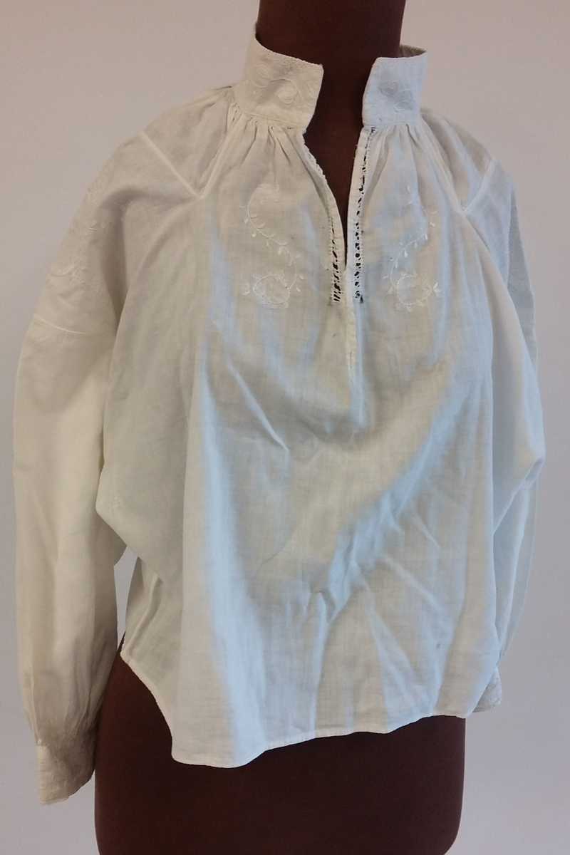 Rødt underskjørt med kappe og lomme, brodert linskjorte, brodert ull-skjørt, brodert ull-vest, brodert lue, brodert veske og blått brodérgarn i ull.