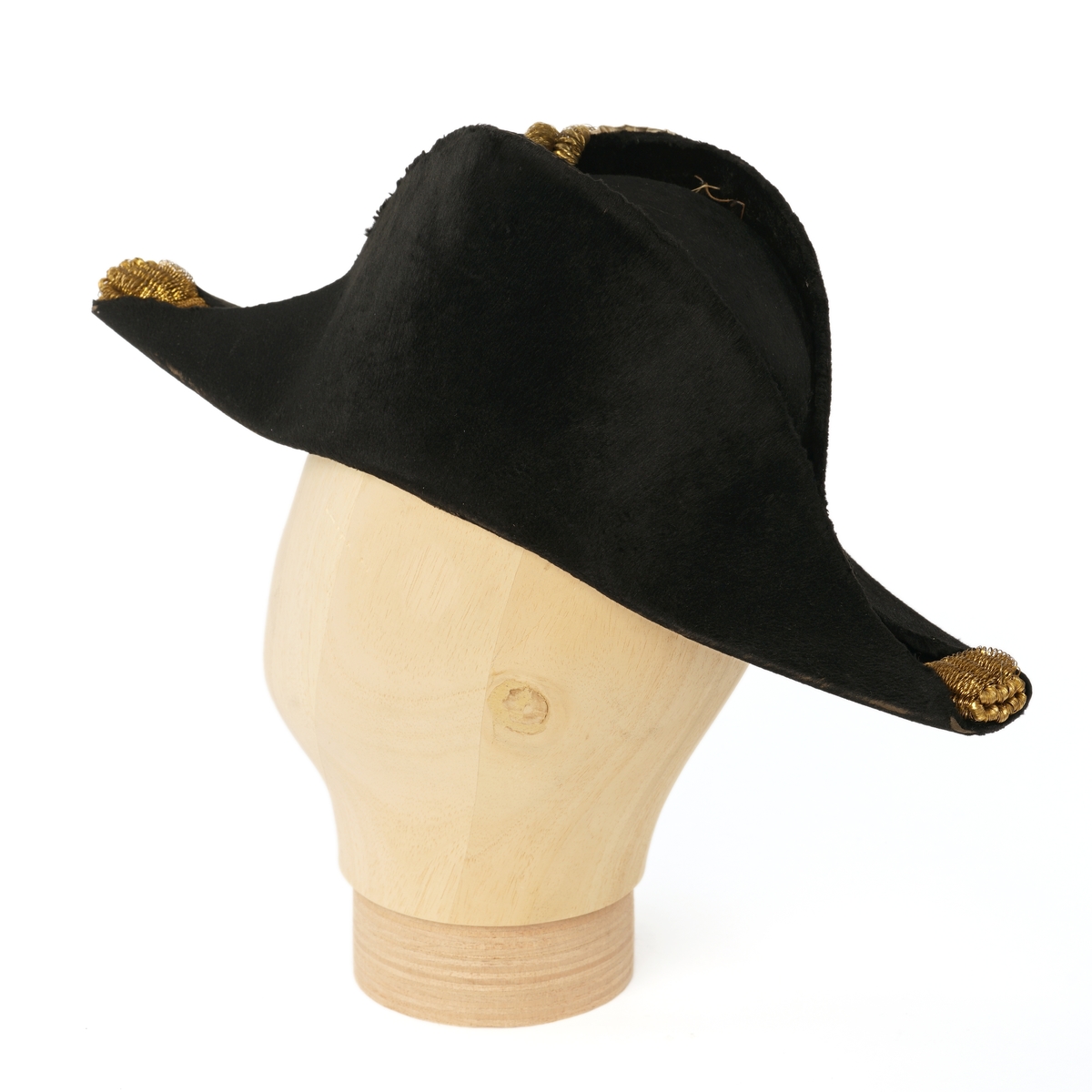 Snutehatt av sort, velurlignende stoff. Rød-hvit-blå kokarde, gulltresse med riksløveknapp. Gullpynt i hver snute. Brunn skinn til svetterem, blå silkefôr. To sort knapper (en mangler) i toppen av innsiden pull.
Metall hatteske til snutehatt.