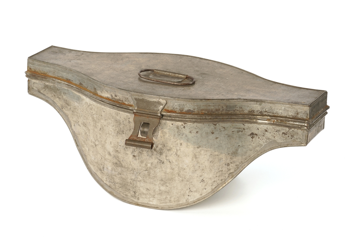 Snutehatt av sort, velurlignende stoff. Rød-hvit-blå kokarde, gulltresse med riksløveknapp. Gullpynt i hver snute. Brunn skinn til svetterem, lys lilla silkefôr. 
Metall hatteske til snutehatt.