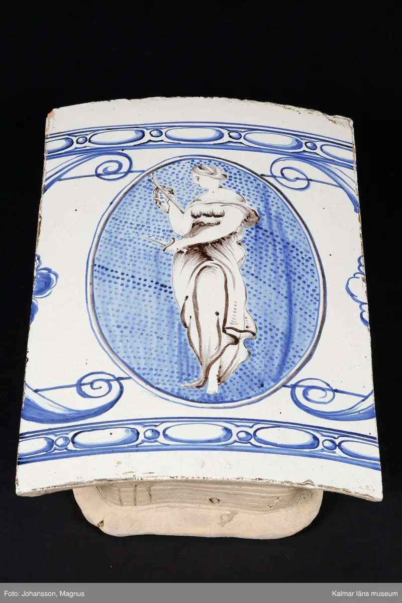 KLM 9414. Kakelugn. Rund, vitglaserad med blå dekor i form av kvinnofigurer, bladrankor, mm. Av typiskt gustaviansk form, rikt dekorerad. Datering, 1790-1800. Till kakelugnen finns ett par luckor av mässing med ram samt inre luckor av järn, 36x31,5 cm.

Förteckning över samtliga kakel, med mått inom parentes, gjord i samband med inventering 1964:
:1. 29 st fasadkakel (32x22 cm)
:2. 5 st krönkakel (29x14 cm)
:3. 4 st listkakel (7x24 cm)
:4. 13 st kakelfragment
