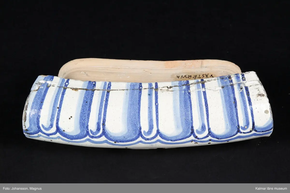 KLM 9414. Kakelugn. Rund, vitglaserad med blå dekor i form av kvinnofigurer, bladrankor, mm. Av typiskt gustaviansk form, rikt dekorerad. Datering, 1790-1800. Till kakelugnen finns ett par luckor av mässing med ram samt inre luckor av järn, 36x31,5 cm.

Förteckning över samtliga kakel, med mått inom parentes, gjord i samband med inventering 1964:
:1. 29 st fasadkakel (32x22 cm)
:2. 5 st krönkakel (29x14 cm)
:3. 4 st listkakel (7x24 cm)
:4. 13 st kakelfragment