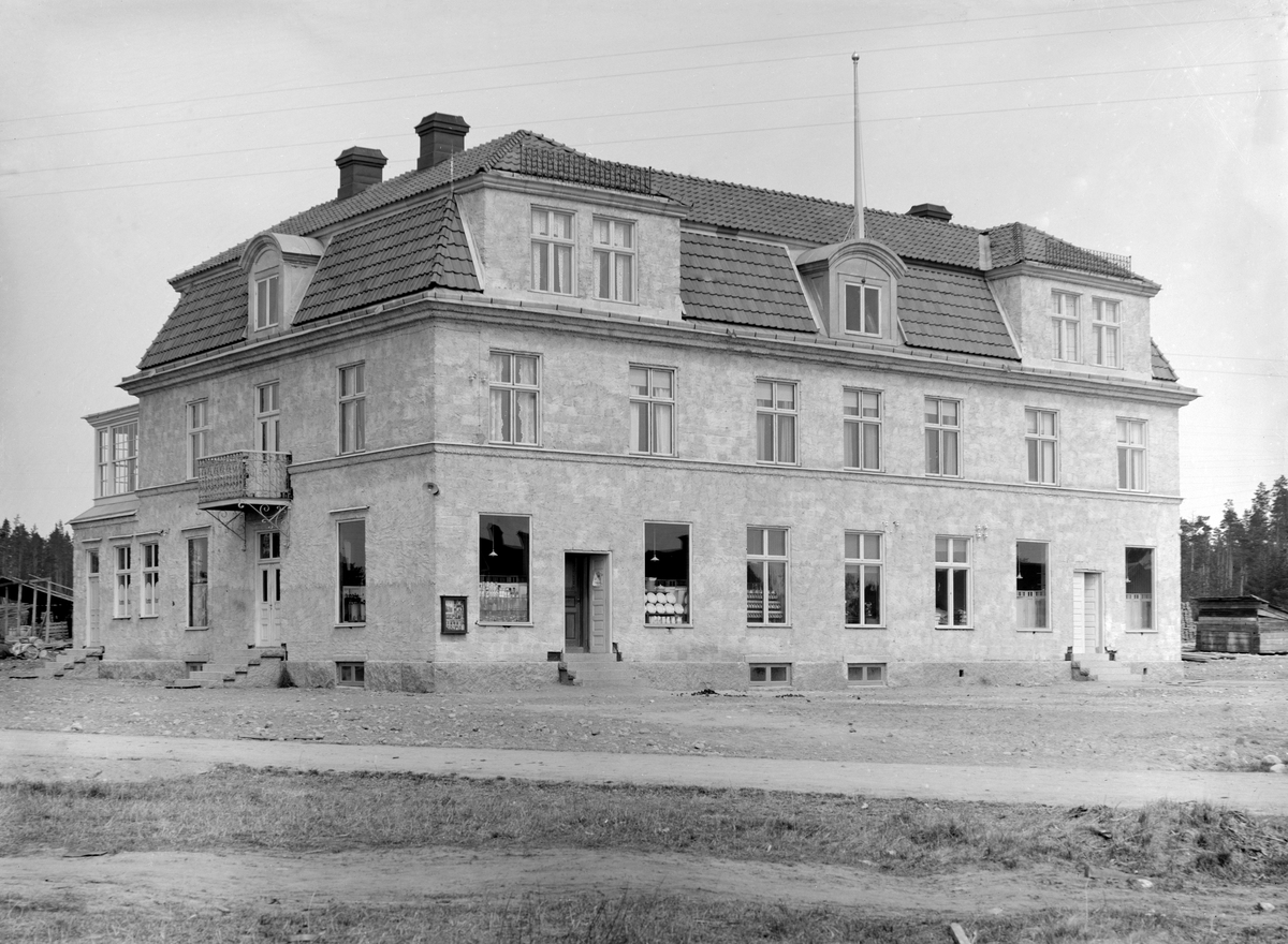 Solhaga i Österbymo uppfördes 1915 genom grosshandlare Georg Elmbergs försorg. Byggnaden inrymde två större butikslokaler i gatuplanet och fyra bostadslägenheter i de övre våningarna. Vid tiden för bilden var byggnaden som synes inte helt färdigställd.