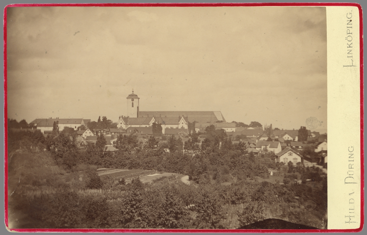 Tidigt panorama över Linköping. Centralt ses stiftets domkyrka som den tog sig ut på 1870-talet. Det så kallade Hårlemanska tornet tillkom vid en omfattande ombyggnad av kyrkan under åren 1847-1858. För ombyggnadens ritningar stod arkitekten Carl Hårleman. Under en genomgripande ombyggnad under åren 1877-1886 kom kyrkan att kraftigt omdanas och i stora drag erhålla sitt nuvarande utseende. I förgrunden breder Trädgårdsföreningens odlingar ut sig.

Anm: Det finns skäl att anta att Hilda Düring här återanvänt fotografiet från faderns (Frans Dyring) produktion.
