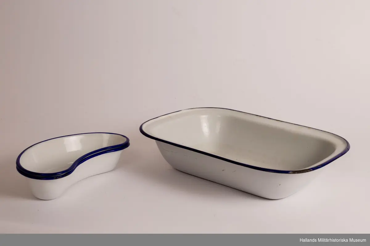 Ett djupt fat. rektangulärt, vit och med blå kanter. Emaljerad metall. Fabriksmärkt på undersidan. 30 cm.