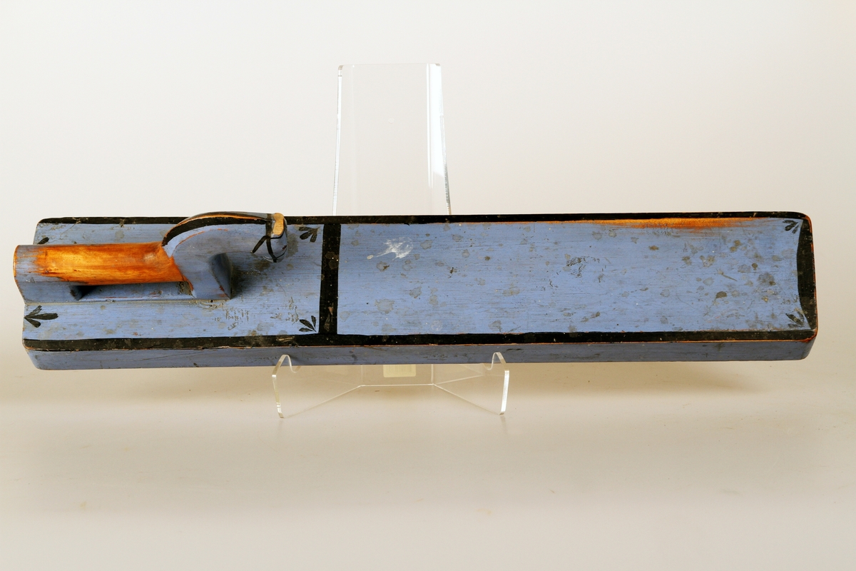 Blåmalt mangletre med svart rand rundt kanten, en svart strek tvers over foran hestehodet, blad i hjørnene, hesten har uvanlig flott reisning med svart man og påmalt hodeplagg. Kavle følger med.