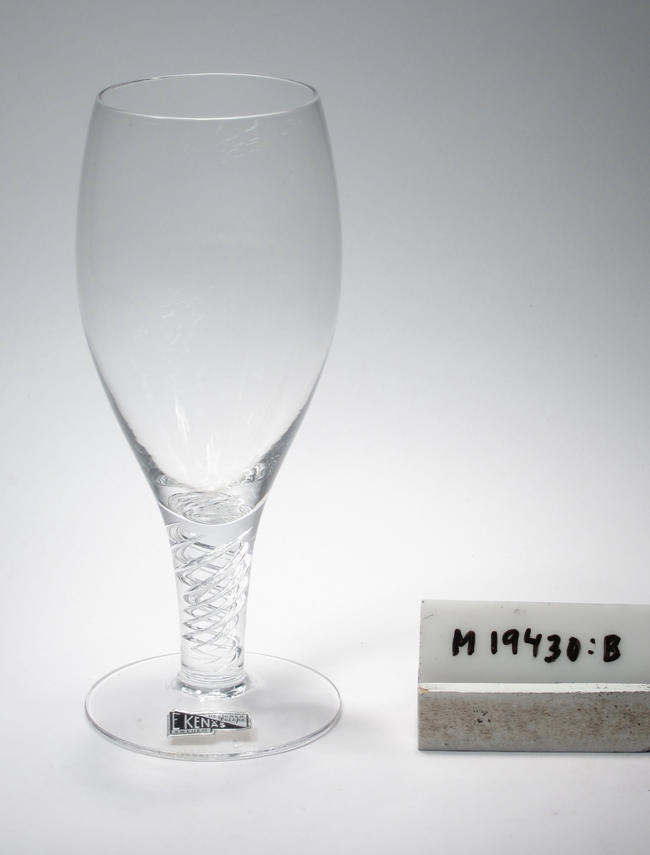Glas på ben och fot.
Formgivet av John Orwar Lake.
Beskrivning: Övre delen konvex, nedre delen konkav med direkt övergång i benet. I benet två spiralslingor.
Färg: Ofärgat klarglas.
Mått: Ovan anges höjd och maxdiameter.
Inskrivet i huvudkatalogen 1968.
Funktion: Glas