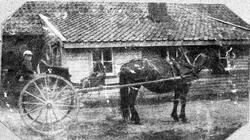 Christian Aasland i karjolen framfor brunnhuset.