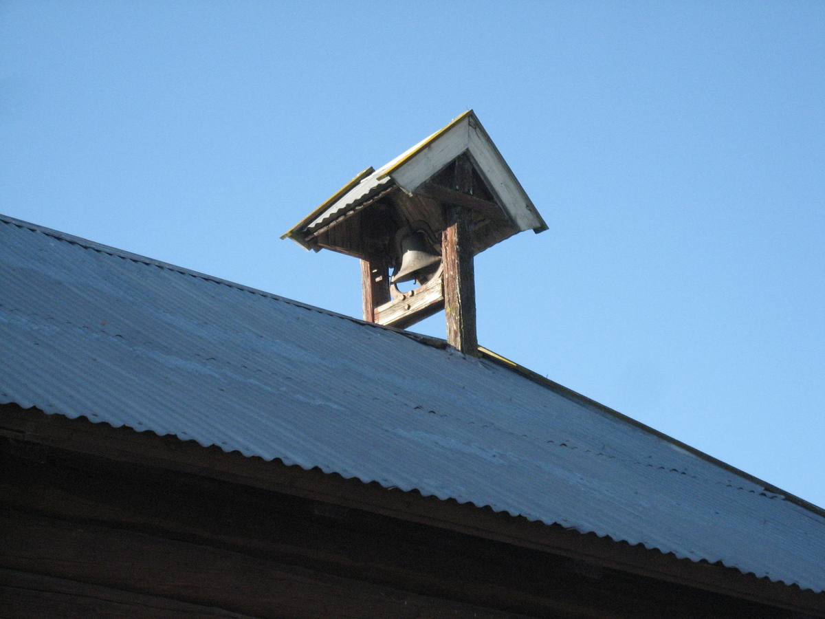 På gården Jemli står klokketårnet på endeveggen av stabburet og har et enkelt saltak.