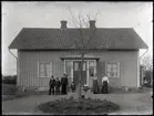 Okänd familj framför hus