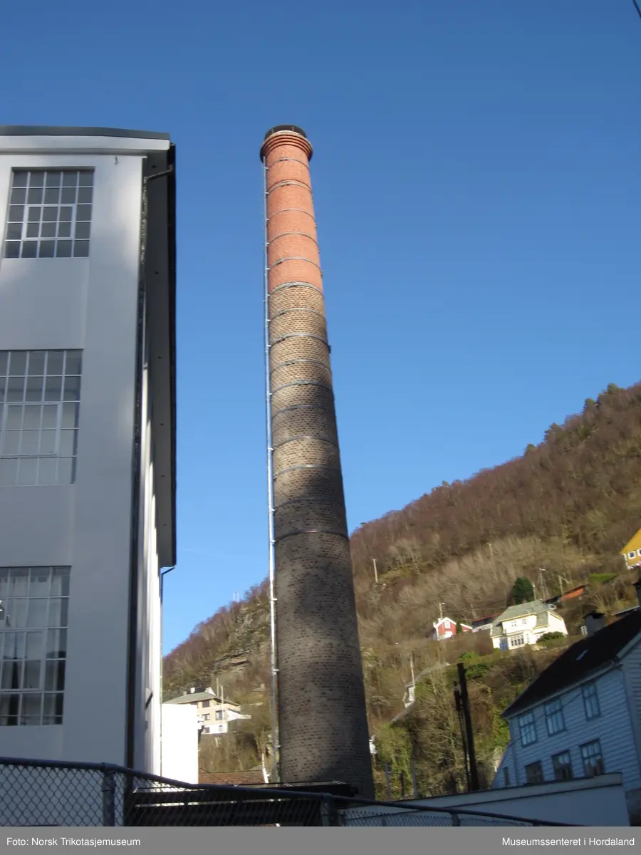 Del av produksjonslokala til Salhus Tricotagefabrik (1859-1989) bygd i 1903. Fyrhus og skorstein til fabrikken, med oljekjel i eitt rom, fyrkjel i den andre delen, og fabrikkskorsteinen.