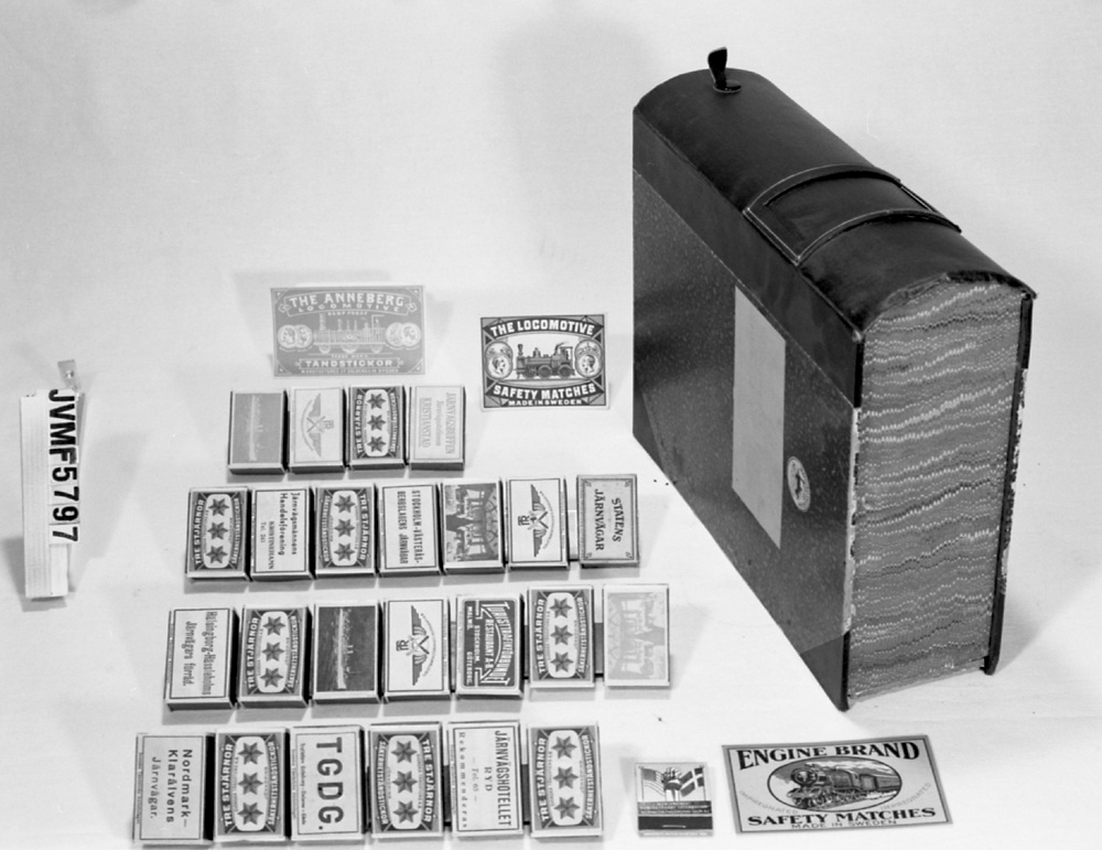 En samling tändsticksaskar och etiketter med järnvägsanknytning, förvarade i en bokformad låda.

Mått på askar  
3st. etiketter med ENGINE BRAND SAFETY MATCHES MADE IN SWEDEN.
3st. etiketter med THE ANNEBERG LOCOMOTIVE.
4st. etiketter med THE LOCOMOTIVE SAFETY MATCHES.
2st. askar märkta TGDG. 2st. NORDMARK KLARÄLVENS J.
2st. askar märkta STOCKHOLM-VÄSTERÅS-BERGSLAGENS JÄRNVÄGAR.
2st. askar märkta JÄRNVÄGSHOTELLET RYD TEL. 65 Rekommenderas.
3st. askar märkta TR TURISTFÖR A-B. Röd skrift. 2st. JÄRNVÄGSBUFFE'N.
2st. askar märkta TR TURISTFÖR A-B. Blå skrift. 2st. STATENS JÄRNVÄGAR
2st. askar märkta TR MED RESTAURANGBILD PÅ BAKSIDAN. Blå skrift.
2st. TURISTFÖR, 2st. HHJS förråd, 2st. J.Handelsförening. 1st. NEW SWEDEN.