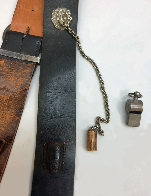 Konduktörsväska av brunsvart läder med 97 mm brett silverfärgat lokemblem på lockets framsida. Väskan har ett brett bandolär med silverfärgade spännen. Bandoläret har även en silverfärgat lejonmaskaron med kedja med en träplugg i änden. Pluggen kan sättas fast i en liten hållare av läder som varit fastsytt på bandoläret.
I väskan ligger en silverfärgad visselpipa (Jvm 23048:2), samt en läderplugg som inte ser ut att härstamma från denna väska.
Bandoläret är lagat på baksidan med ljusbrunt läder i höjd med hålen för spännet.
Väskan är byggt kring en inre behållare av metall.

Väskan har förslutits med en (avbruten) lädertamp och gevärsknapp som sitter på undersidan. På lockets insida finns en påklistrad förstärkning av ljusbrunt läder.
Väskan är skadad på baksidan, där locket börjat lossna från väskans bakstycke.