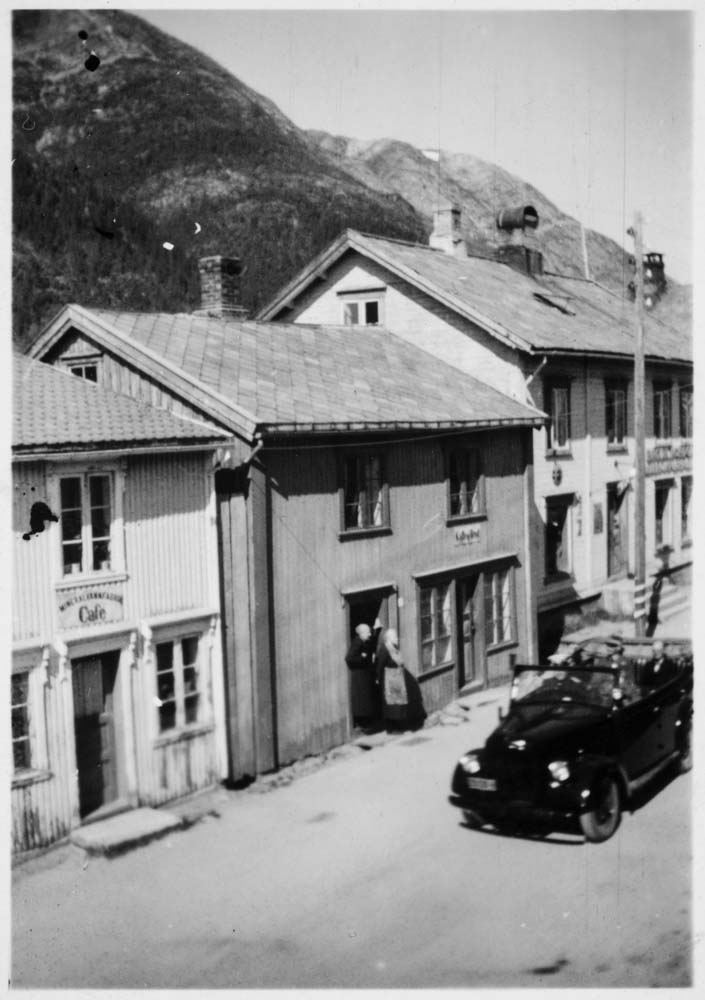 Kong Haakons besøk i 1946, i åpen bil gjennom byen. Mineralvannfabrikken til venstre. Krysset Peter Bechs gate og Sjøgata.