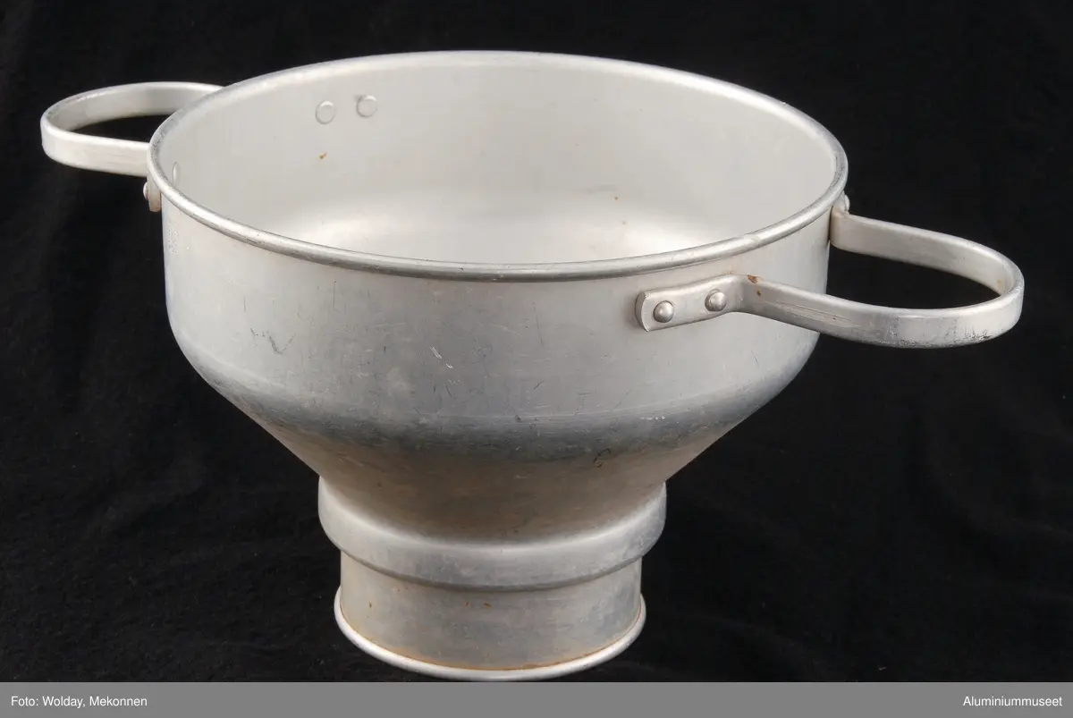 Teknikk: Melkesilen er håndtrykket fra rondell. Den er renskåret og falset i begge ender. 2 stk. håndtak av Al-profil 4 x 12 mm.er påklinket.
 Det medfølger :
1 stk. silplate, finstanset.
1 stk. prelleplate, grovstanset.
1 stk. fjærklemme.
Sil med deler leveres beiset.

Form: Sylindrisk form med konisk overgang til spanndiameter.
