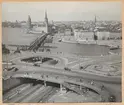 Bilden föreställer vyn över gamla stan i Stockholm från Katarinahissen med Slussens betonghav i förgrunden.