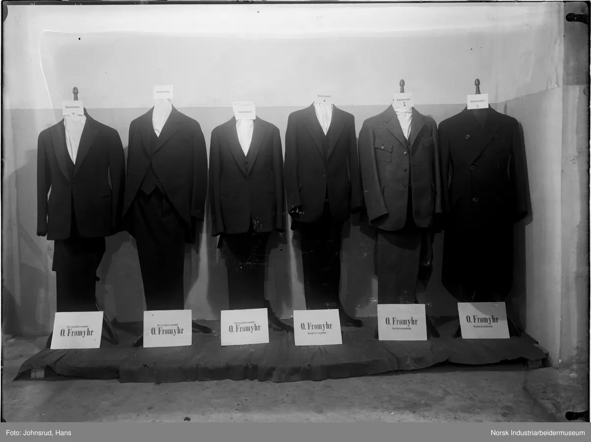 Fylkesutstillingen Kongsberg 1924. Utstilling for skreddermester O. Frømyhr. Seks utstillingsdukker kledd i dress.