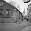 Del av Tanneforsgatan i Linköping med utblick mot Stora torget. Året är 1968 men en nutida betraktare känner igen sig i det mesta. Dock kommer trähuslängan till vänster att rivas kort efter fototillfället för att ge plats för ett modernt affärshus. Även Hushållningssällskapets fastighet, det lägre huset i fonden, kommer vidare att jämnas med marken för att ge yta för affärshuset Filbyter. Vy mot väster från Tanneforsgatans skärning med Klostergatan.