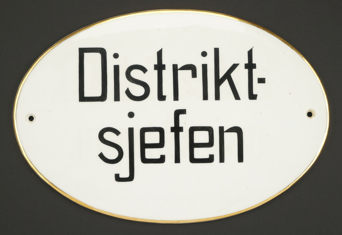 Porselensskilt til dør. Ovalt med sorte bokstaver.