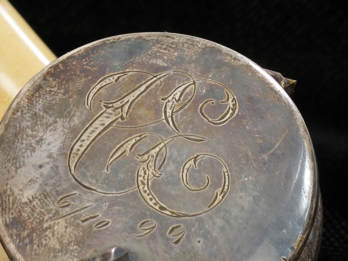 Langpipe med monogram C E (Cristian Eyde). Lys merskum med sølvlokk og beslag. Skaft av  tre  med munnstykke av horn med  flettet tagl. Midtstykke av sort kunststoff. På lokket   inngravert: C E 6/10 99.  Stemplet ved skaftet   P.a. Ø. 830S.  = P.a. Ødegaard Arendal. Fra midt på skaftet til hodet - mørkegrønt (opprinnelig blått)  omullsbånd.  


Om merskum:

Merskum er en massiv form av mineralet sepiolitt, som er et vannholdig magnesiumsilikat. Det oppstår ved forvitring av serpentin.
Merskum danner blekgule eller gråhvite masser som er meget bløte, porøse og flyter på vann, noe som har gitt opphav til navnet. Har en matt, jordlignende overflate som blir blank ved polering.
Merskum er særlig kjent fra Eskisehir i Tyrkia. Materialet brukes til pipehoder og forskjellige prydgjenstander. Forfalskninger er vanlige.
(Kilde: Store Norske leksikon)