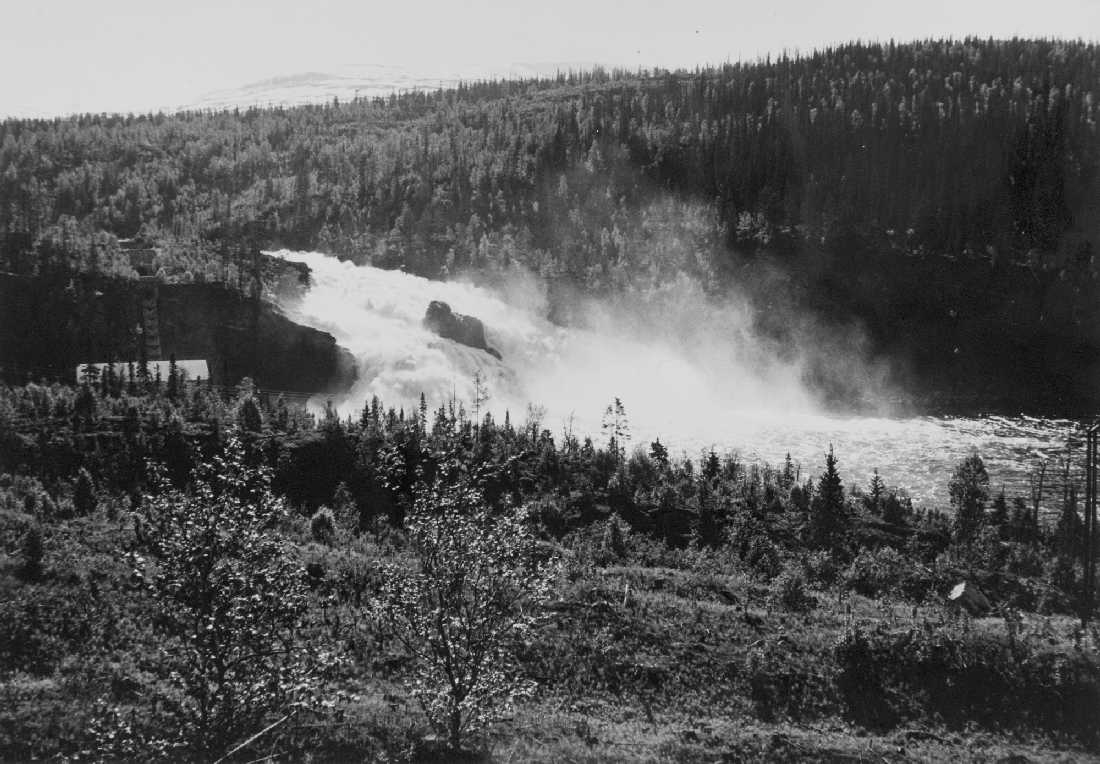 opprinnelig arkivnr. 0572.
Nedre Røssåga. Stabbforsen under vårflommen. Hjelpekraftverket med rørgate i venstre fotokant