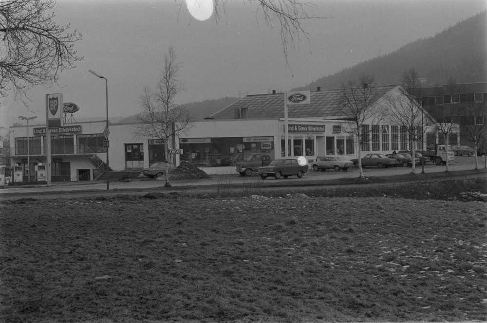 Lind & Greva i Mosjøen, Mars 1975. Markering i forbindelse med 20 år som Ford forhandler.
Bygningene sett fra sør mot nord, Skjervgata i forgrunnen.