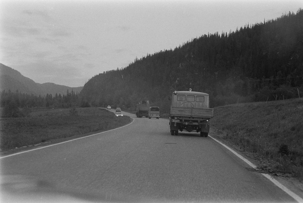 Berging av veivals på Storbjørnvatnet. Bergingen er over og tilskuere og bergingsmannskap kjører tilbake til Mosjøen langs E6.