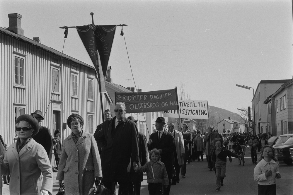 1.Mai i Mosjøen. Demonstrasjonstog i Strandgata, de to husene vi ser helt til høyre, mellom Haugans og Sparebanken, er revet.