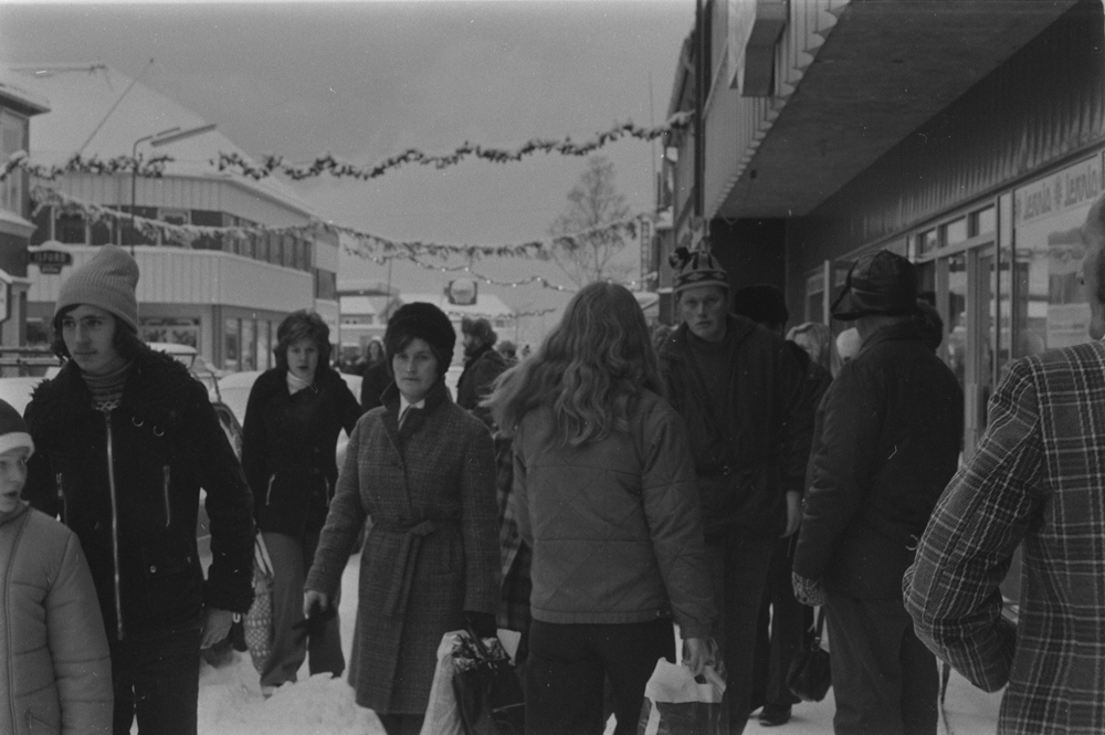 Fra Strandgata pyntet til jul. Julehandel, folk og biler i gata. Julereportasje.