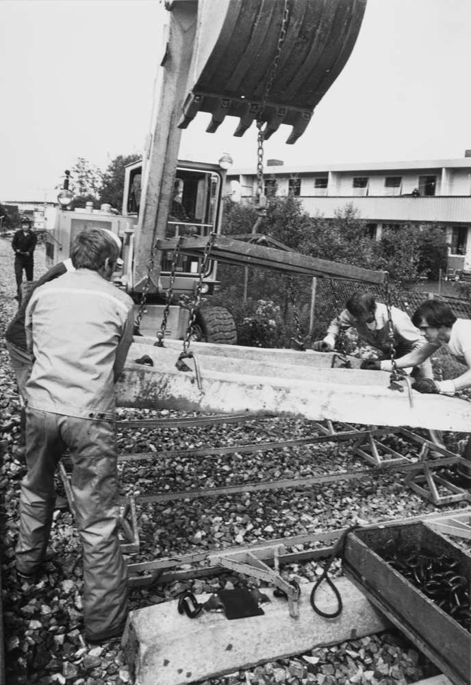 Arbeidslag iferd med å legge nye sviller på jernbanen gjennom Mosjøen. Vi ser Ormen Lange i bakgrunnen.