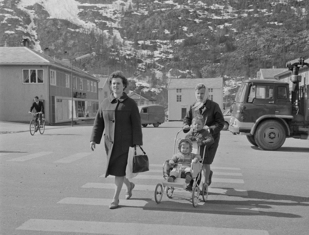 Fra Torget i Mosjøen. To kvinner går over gata, den ene med barn og barnevogn.