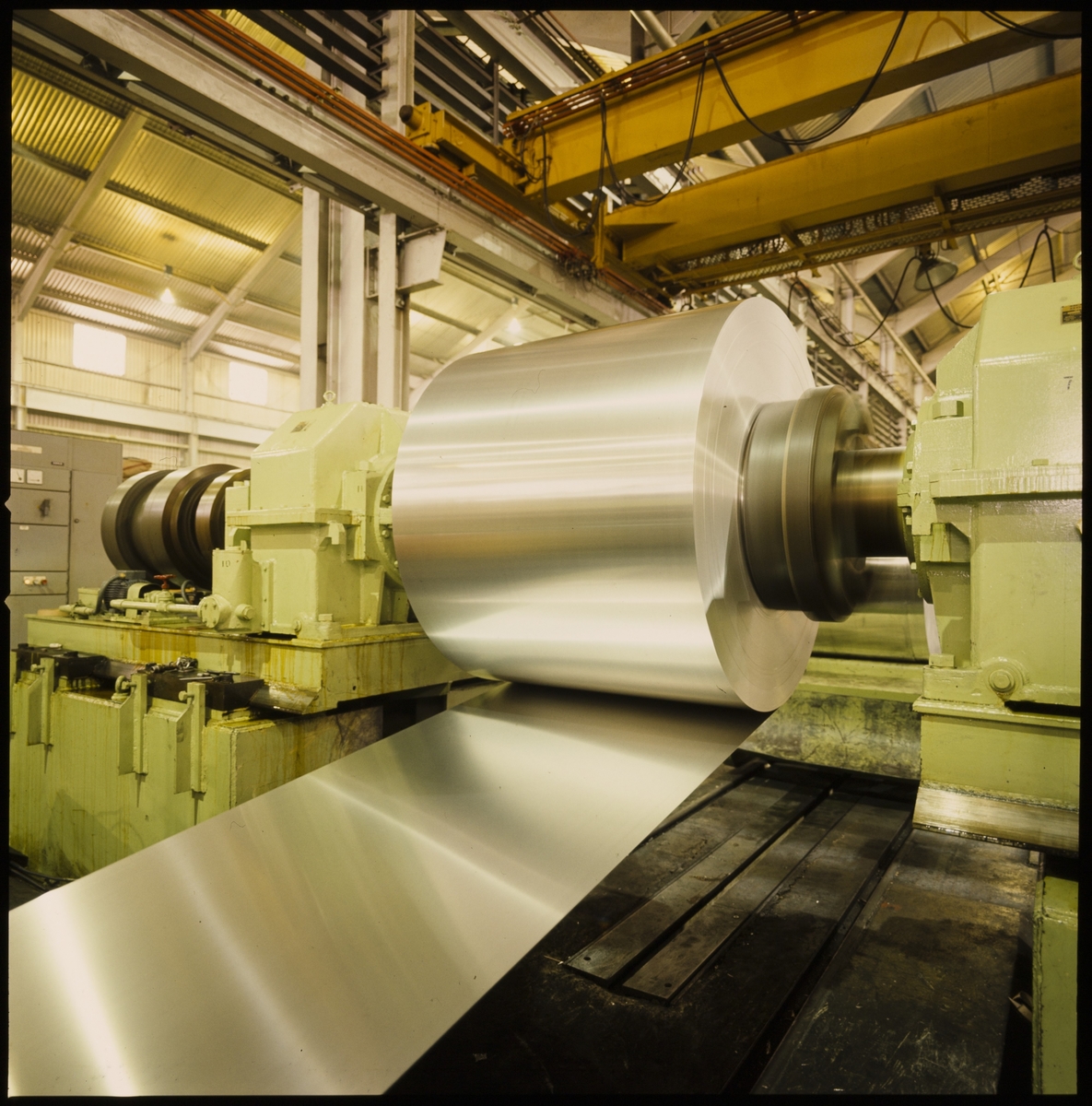 Bilder fra Alnor Aluminium på Karmøy. Det er bilder fra smelteverket, store aluminiumsplater på rull, et verksted, og ulike aluminiumsprodukter.
