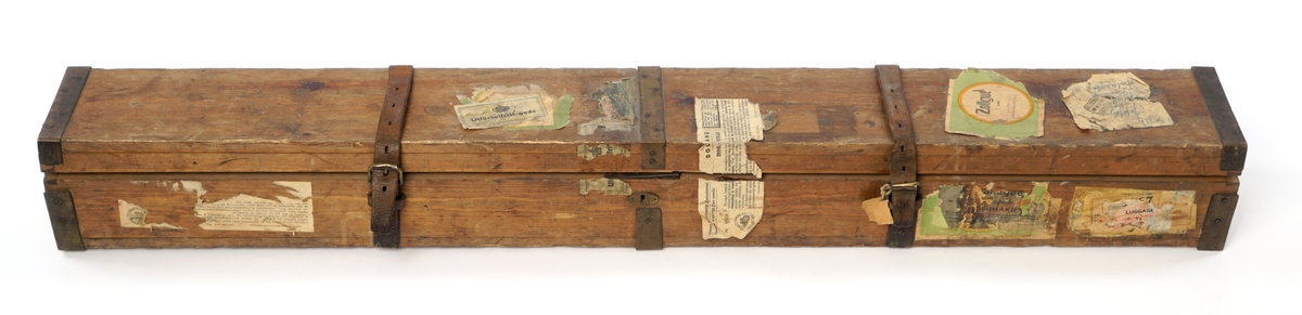 Trekasse med låsbart, hengslet lokk. Nøkkel mangler. Kassen er forsterket med metallbeslag. Lokket kan også låses med to påskrudde lærreimer med spenner. Nøkkelhullet er forsterket med metallbeslag.