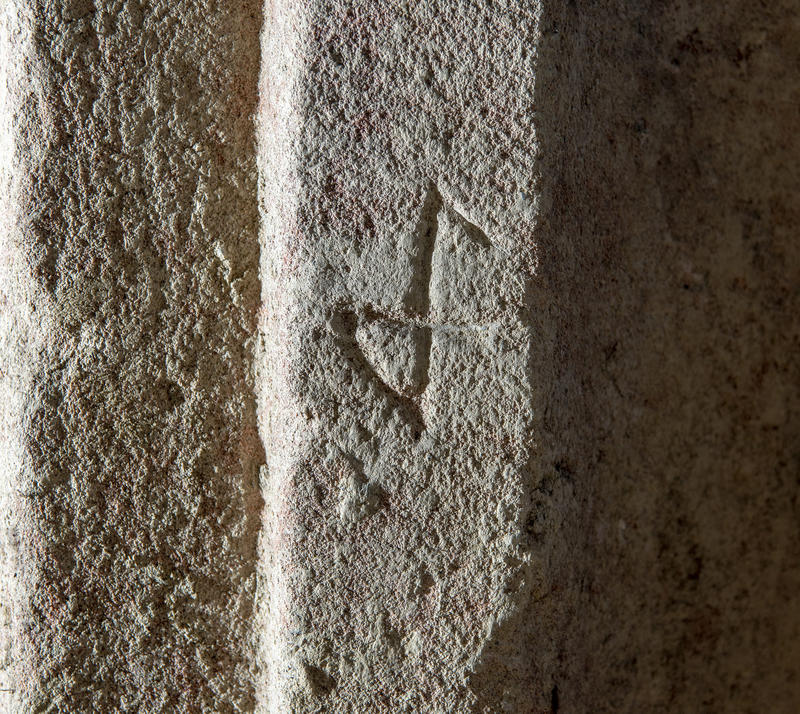 Stone with a carved figure looking like an upside-down P; a Medieval mason's signature mark.