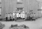 Skolfoto från Spakarps skola i Svinhult. Rimligtvis är läraren Robert Blomqvist som tjänsgjorde vid skolan under åren 1925-31, vilket även ger oss fototillfället i stora drag. Ritsarna runt klassen visar hur fotografen tänkt sig bildens slutresultat.