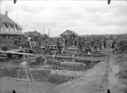 Utbyggnad av bangården. Byggnadsarbetare  uppställda för fotografering.