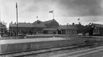 Järnvägsstationen i Eslöv. Bilden tagen i samband med, eller strax före, invigningen av det nya stationshuset 1915, därav utsmyckningarna.
Till vänster i bild syns ett pågående arbete vid plattformen.
Notera att flaggorna ser inverterade ut, detta är en bieffekt av den typ av film, ortokromatisk film, som användes vid den här tiden.