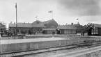 Järnvägsstationen i Eslöv. Bilden tagen i samband med, eller strax före, invigningen av det nya stationshuset 1915, därav utsmyckningarna.
Till vänster i bild syns ett pågående arbete vid plattformen.
Notera att flaggorna ser inverterade ut, detta är en bieffekt av den typ av film, ortokromatisk film, som användes vid den här tiden.