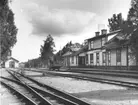 Växeln i förgrunden leder till tanklokstallet.
Till vänster syns den gamla Jjärnvägsverkstaden och bakom den nya vattentornet från 1913. Längst bak till höger om gamla verkstaden skymtar nya järnvägsverkstaden från 1913.
Fordonet är den så kallade motorbussen. En motorvagn byggd på ett lastbilschassie. Användes under några år i ett försök att rationalisera persontrafiken.