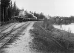 Trafikplats anlagd 1897. En- och en halv vånings stationshus i trä. Observera bromsarna som sitter uppe på de lastade vagnarna. DONJ lok 6 