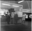 Herrar samt dam som nyttjar postkontoret kopplat till Järnvägsstationen vid utställningen i Göteborg 1962.