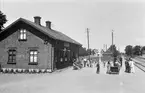 Rinkaby station. Mannen i vitt är stationspersonal, iklädd sommaruniform.