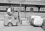 Gaffeltruck med lådor Gotlands Fiskförsäljning. Troligen Stockholm Centralen.
SJ CC2-vagnar i bakgrunden.