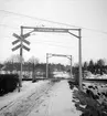 Vägövergångar. Kryssmärke med vinklar, flera spår nånstans mellan Stockholm Central och Uppsala. Varning för tåg.